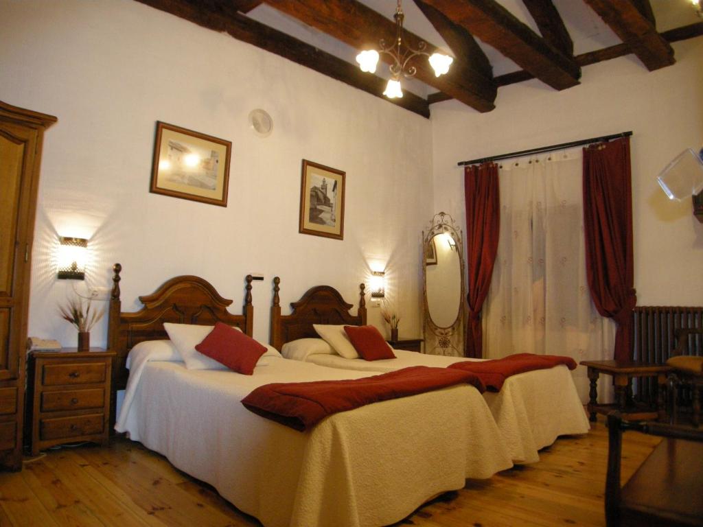 Chañe卡门乡村民宿的一间卧室配有两张床和镜子