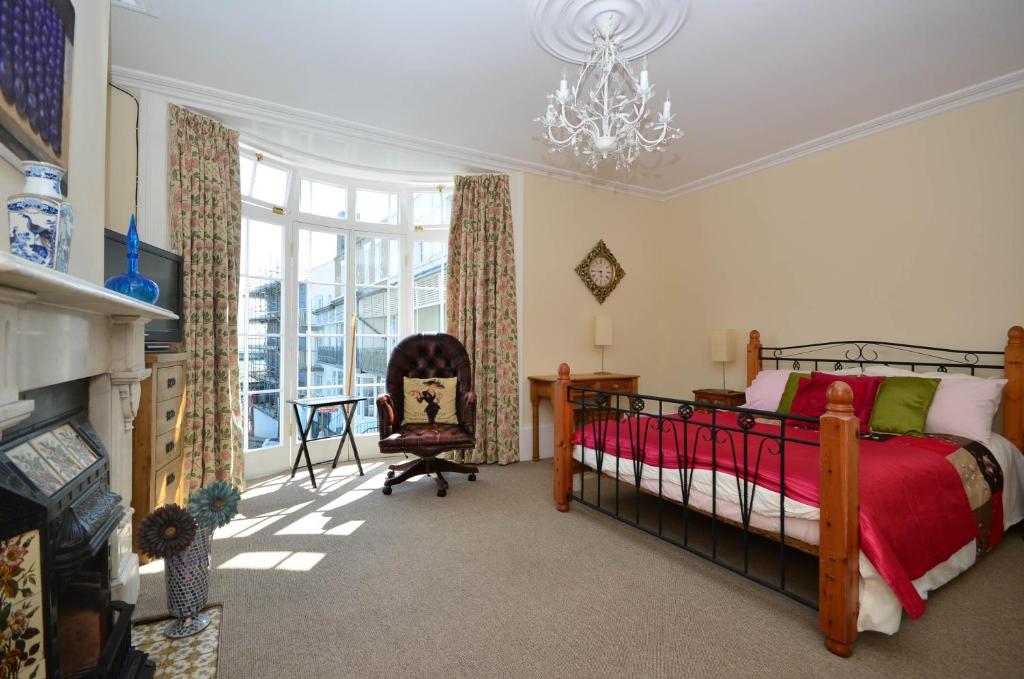 拉姆斯盖特Casa Mar Bella的一间卧室配有一张床、一把椅子和一个吊灯。