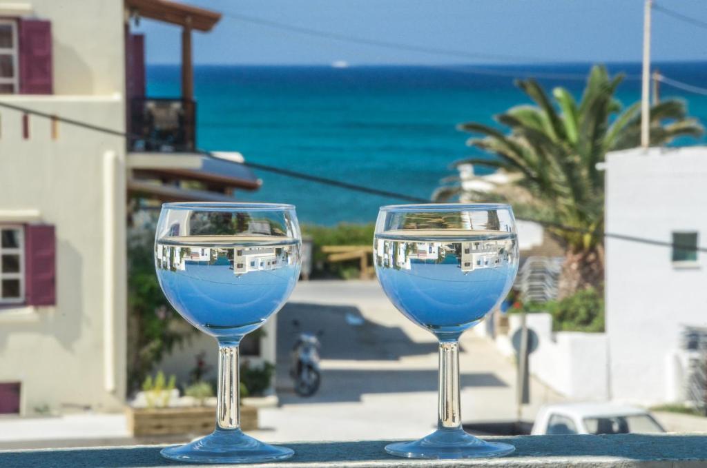 圣安娜纳克索斯星期天一室公寓酒店的两杯酒杯坐在桌子上,背靠大海