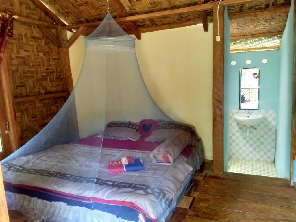 武吉拉旺Bukit Lawang Landak River Guest House的配有蚊帐的客房内的一张床位