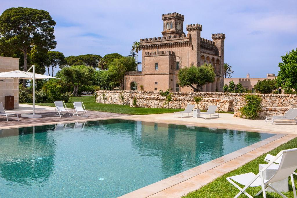 曼杜里亚Vinilia Wine Resort的一座城堡建筑前的游泳池