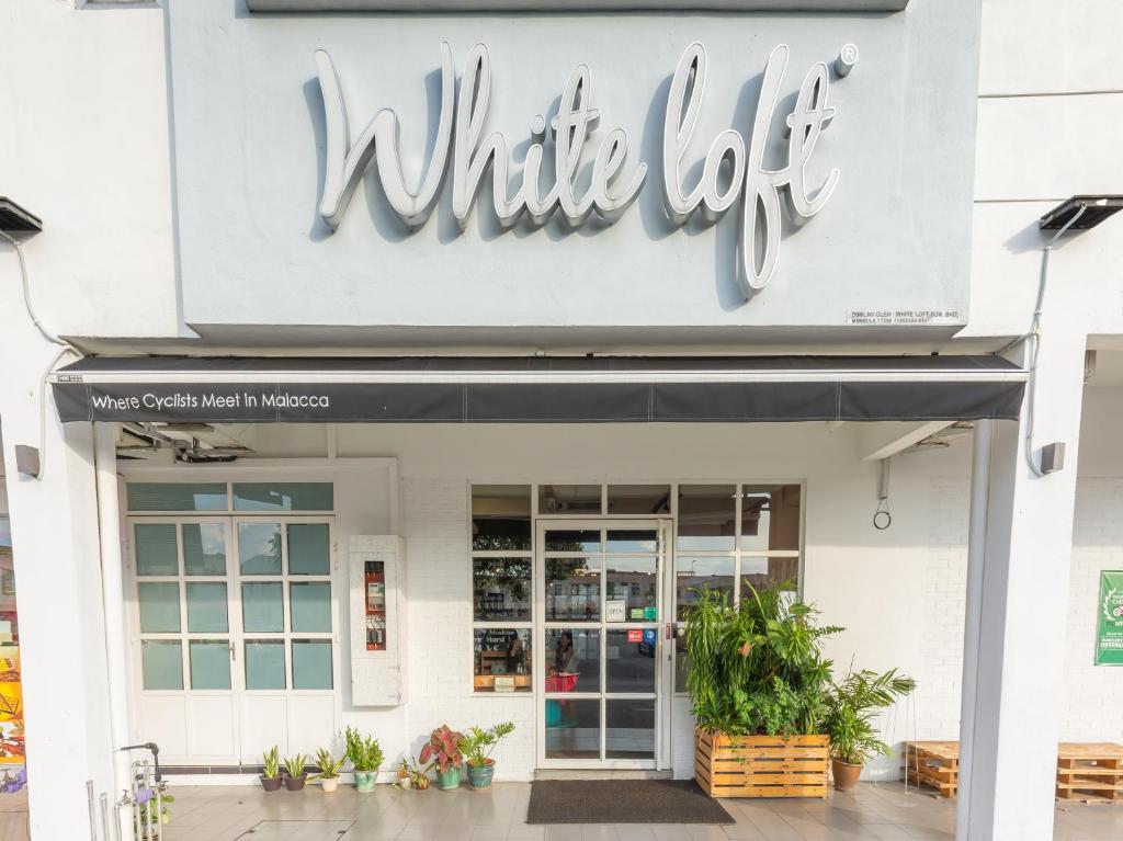 马六甲White Loft Hotel的商店前的白色标志