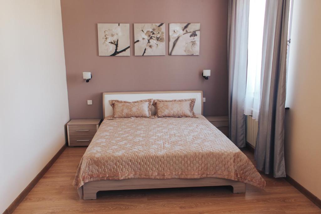 阿克托比Sad Dolgoletiya Hotel的卧室配有一张床,墙上挂有两幅画