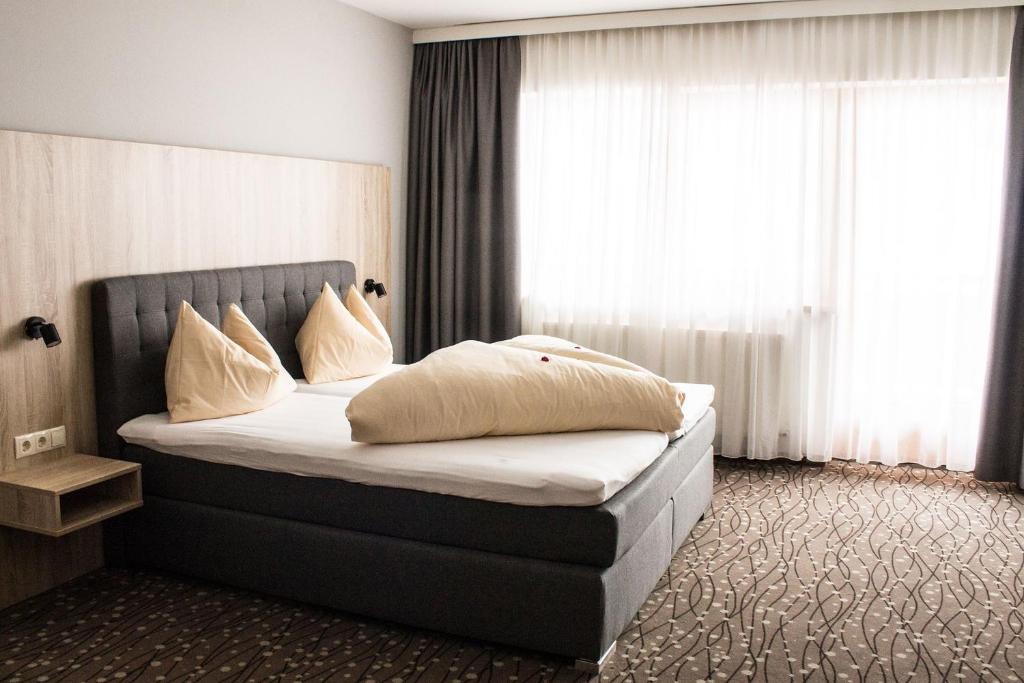 菲根贝格Panorama Lodge Hochfügen的一间卧室配有带白色床单和枕头的床。