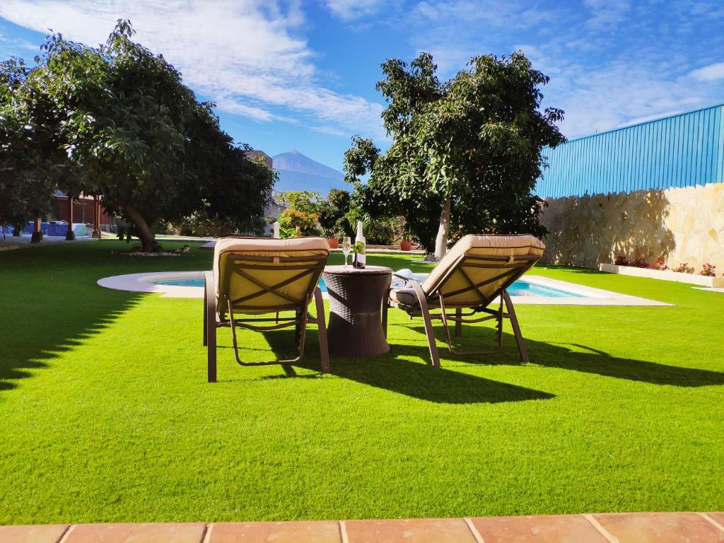 La Victoria de AcentejoVillas Norte Piscina privada climatizada的公园草地上的两把椅子