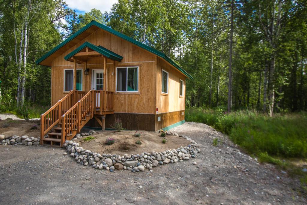 阳光城Talkeetna Wilderness Lodge & Cabin Rentals的森林中间的小木屋