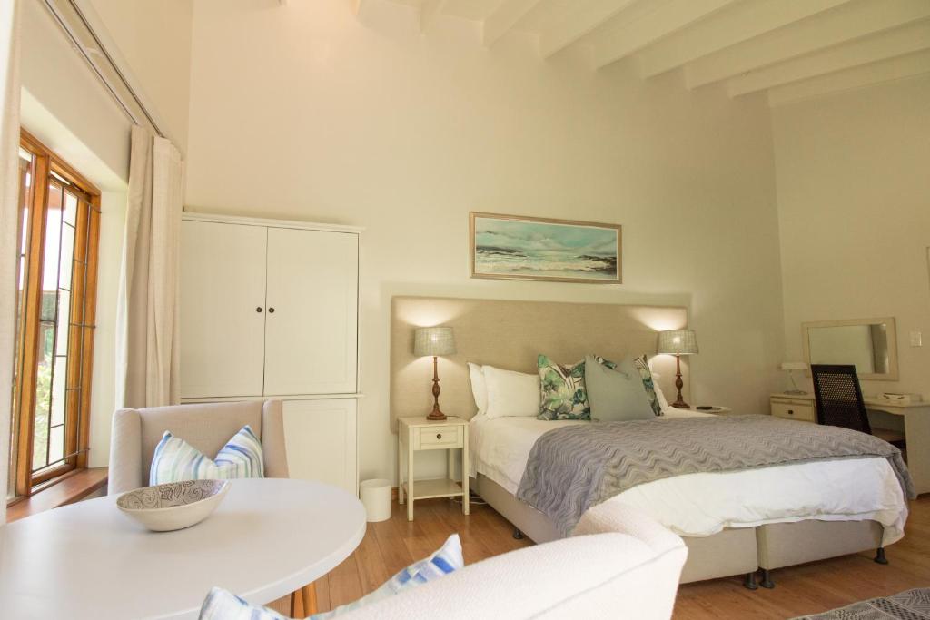 开普敦Oakvale Lodge的卧室配有1张床、1张桌子和1把椅子