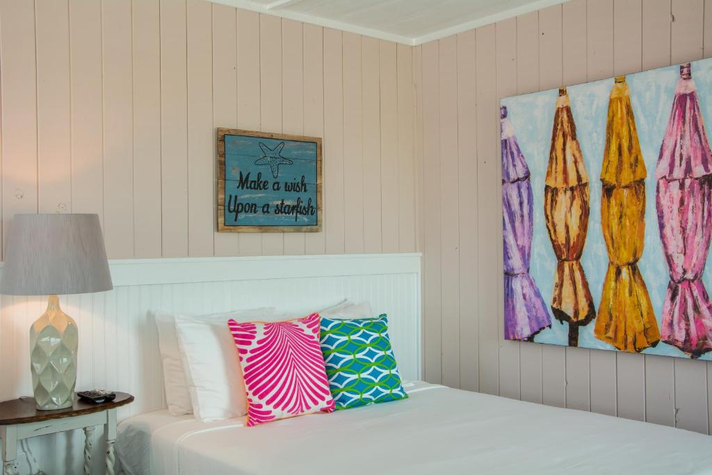斩魔山See Sea Motel的卧室配有一张床,墙上挂有绘画作品