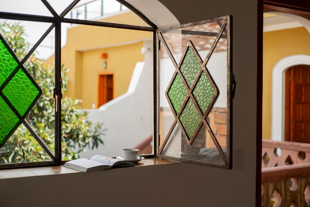 圣克里斯托瓦尔-德拉斯卡萨斯Casa Cafeólogo的玻璃窗户,书上放着一杯