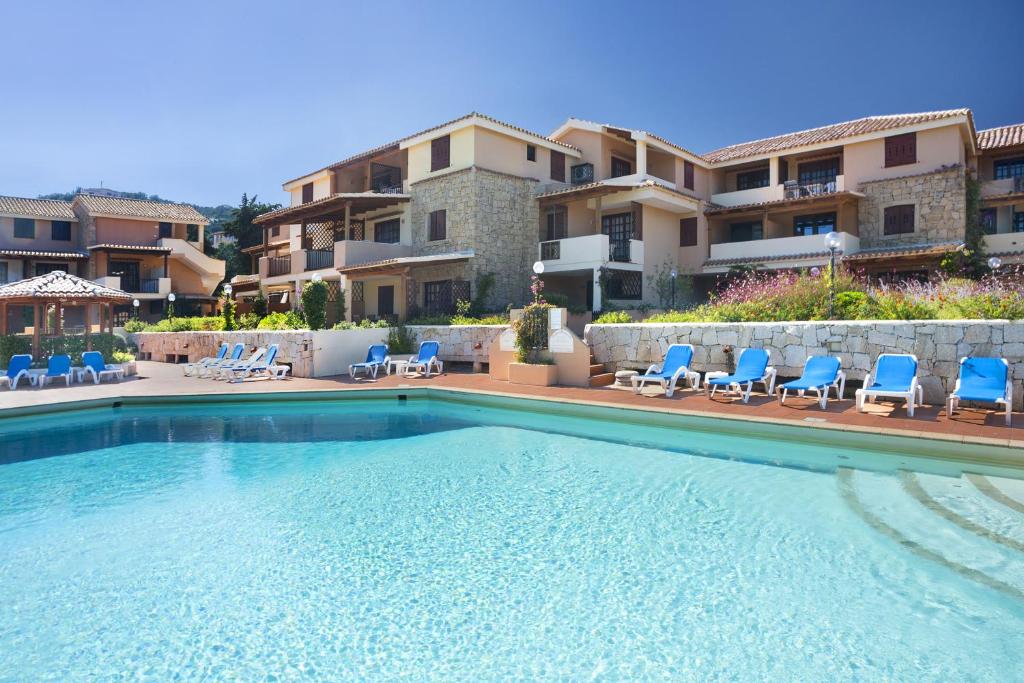 切尔沃港宝佳维利亚公寓式酒店的一座带蓝色椅子的游泳池和一座建筑