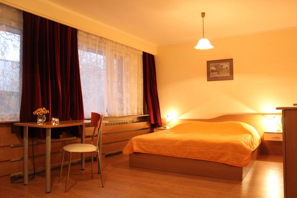 索非亚保加利亚科学院酒店的一间卧室配有一张床、一张桌子和一张桌子