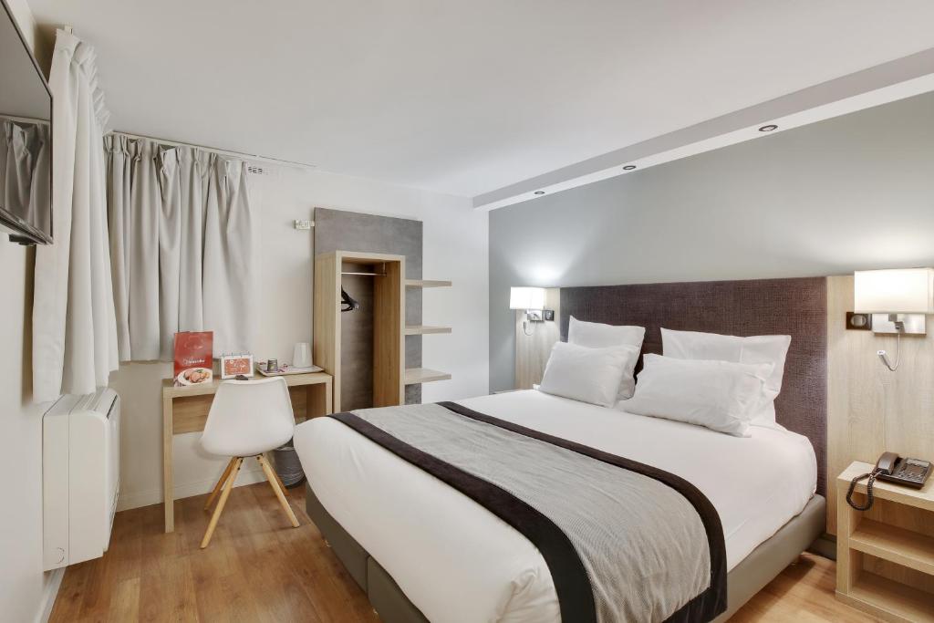 楠泰尔拉曼帝业酒店的卧室配有一张白色大床和一张书桌