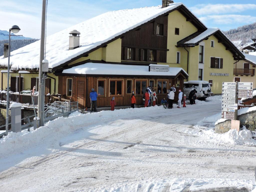 托尔诺麦森讷特酒店的一群人站在一座建筑物外的雪中