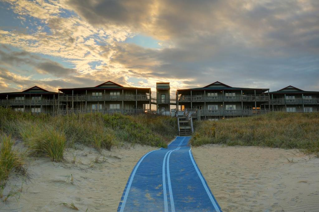 斩魔山外滩群岛海滩俱乐部酒店的海滩上的度假村,沙滩上设有蓝色的走道