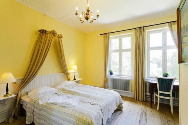 博雷里斯朗德舒洛特酒店的一间卧室配有一张床、一张书桌和一个窗户。