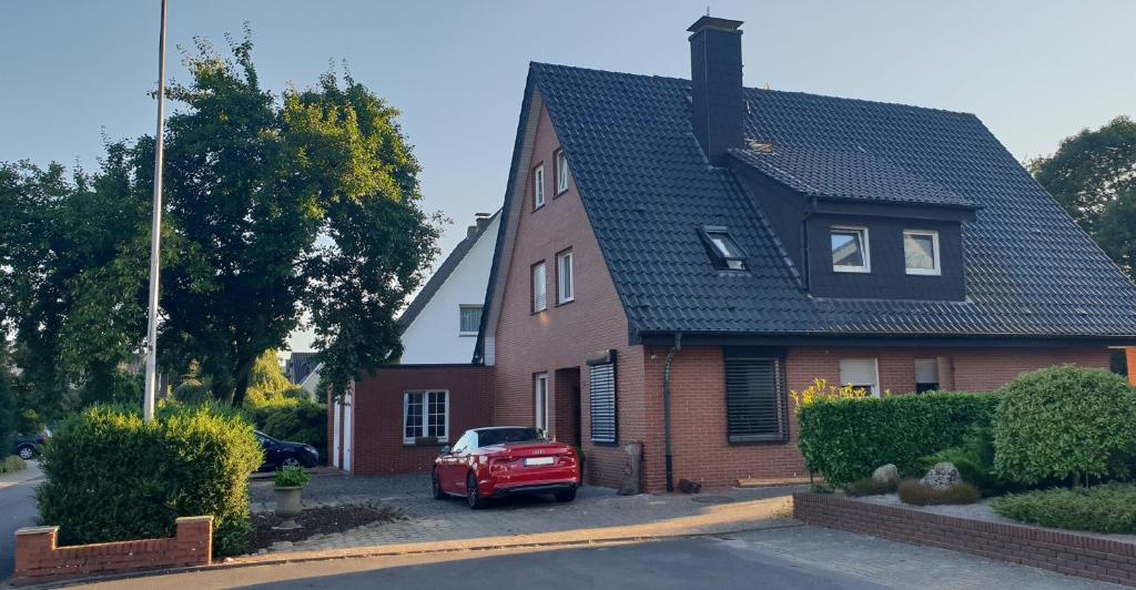 伊本比伦Pension Pommernweg Ibbenbüren的停在房子前面的红色汽车
