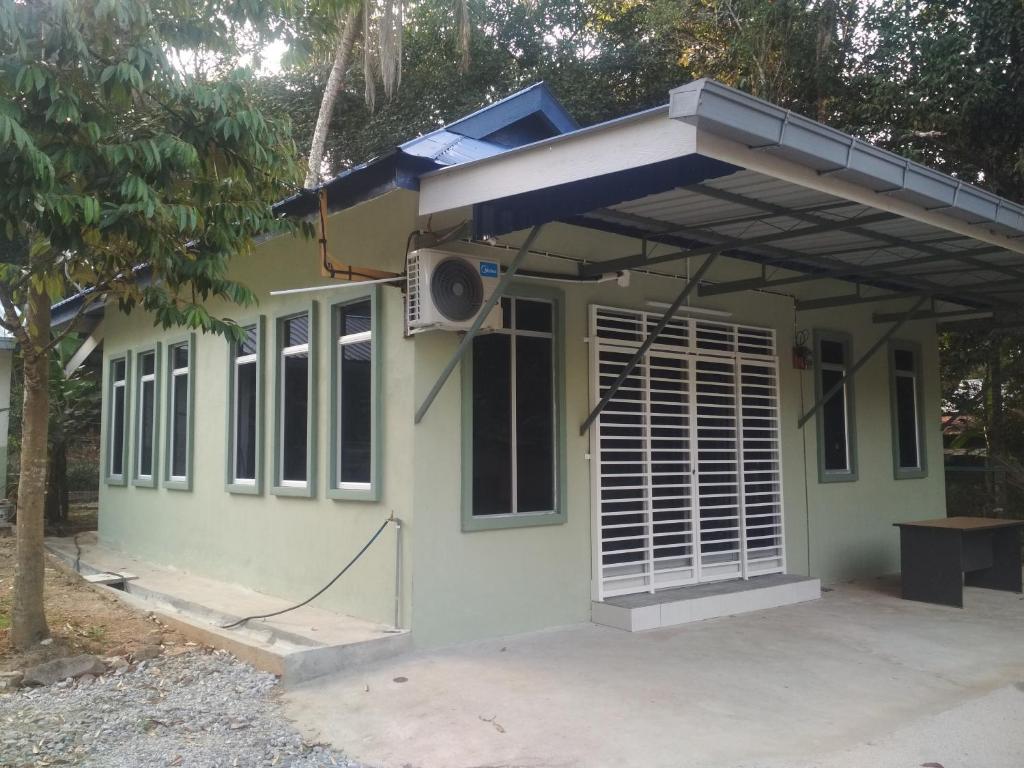 Kampong MerbokDZe Homestay Singkir Genting的一座带屋顶的绿色小房子