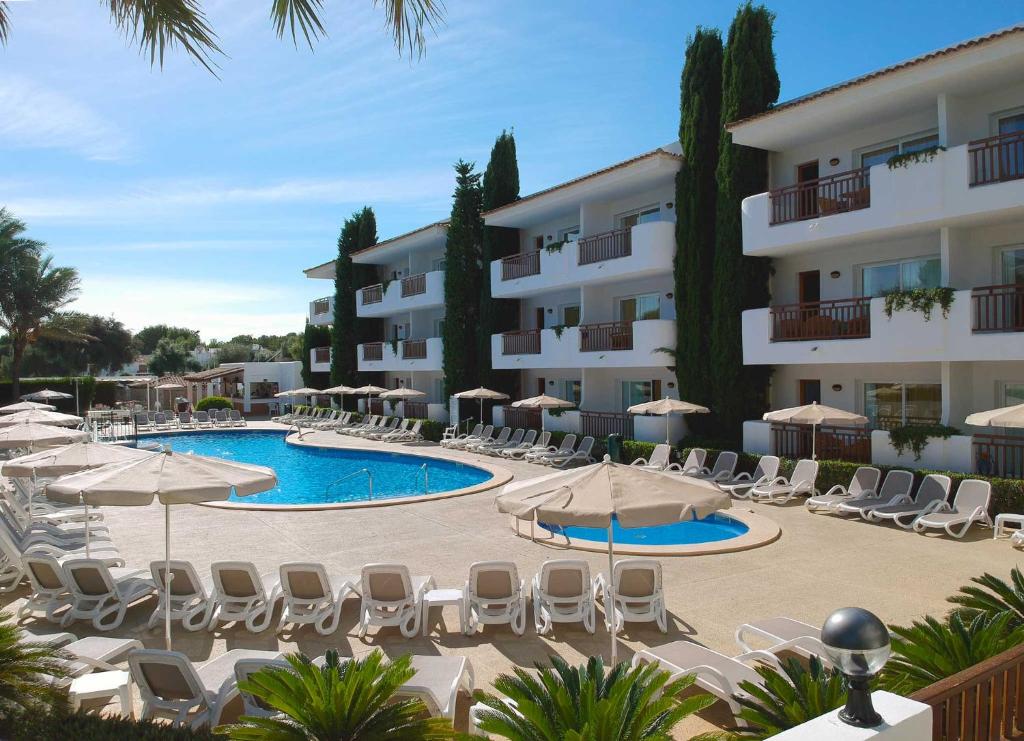 卡拉达沃因图洛特尔埃斯梅拉达花园酒店的一座设有游泳池、椅子和遮阳伞的酒店