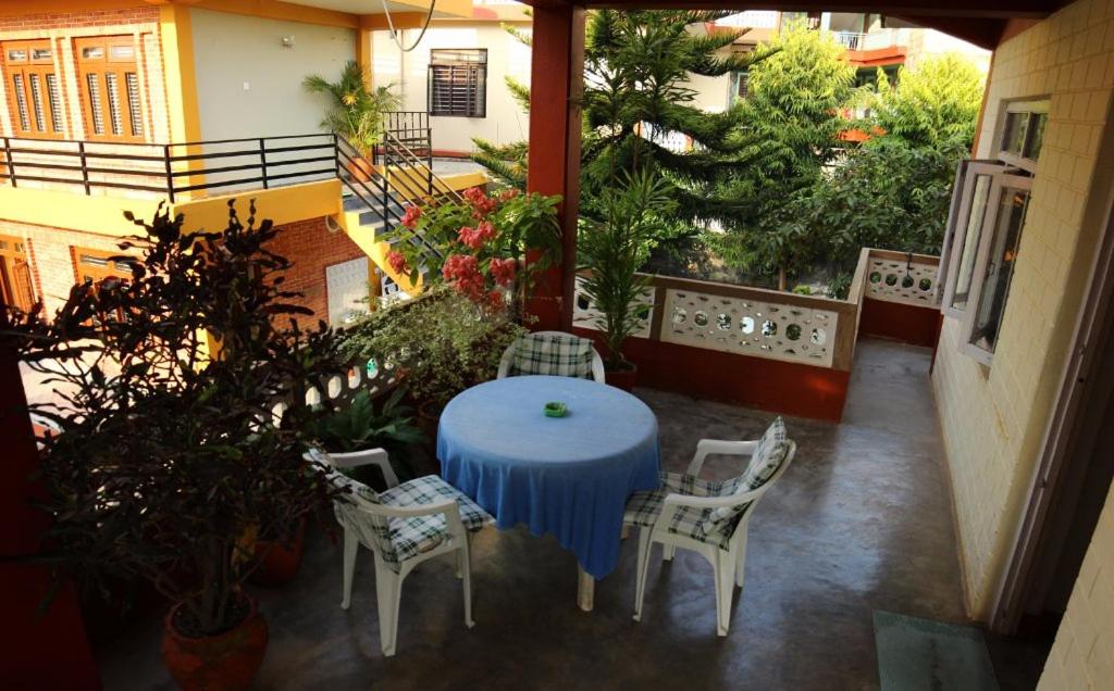 博卡拉新旅者旅馆的阳台上配有蓝色的桌椅