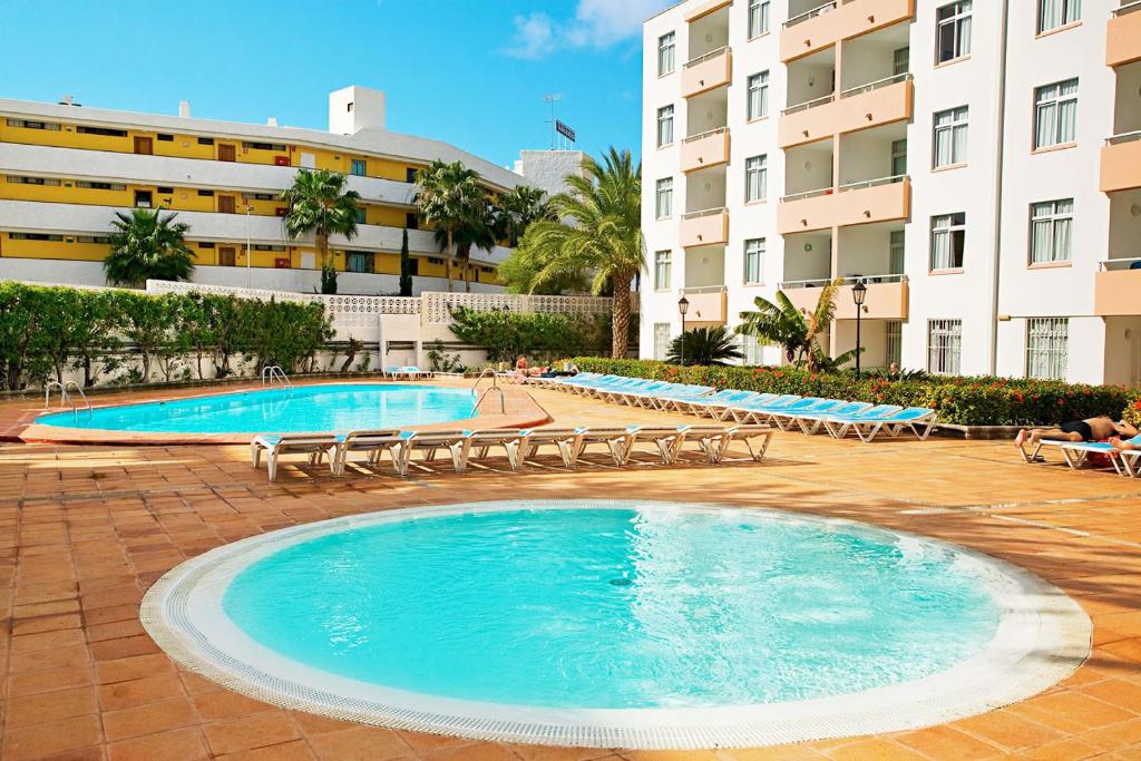 圣巴托洛梅Farilaga Apartments的一座带躺椅的大型游泳池和一座建筑
