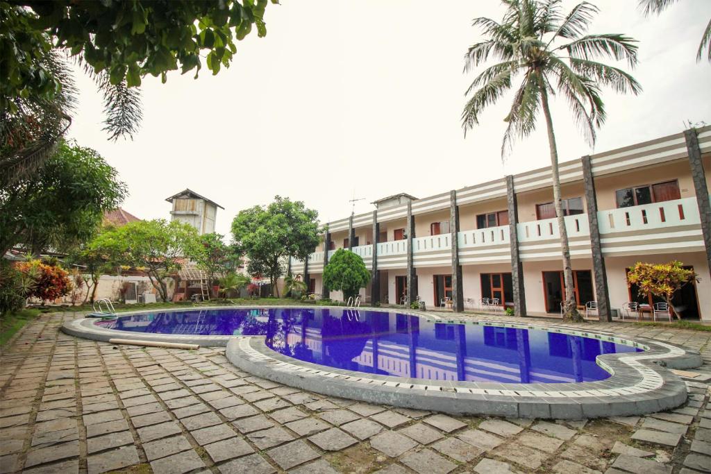 庞岸达兰RedDoorz Plus At Hotel Sofia Pangandaran的大楼前设有游泳池的酒店
