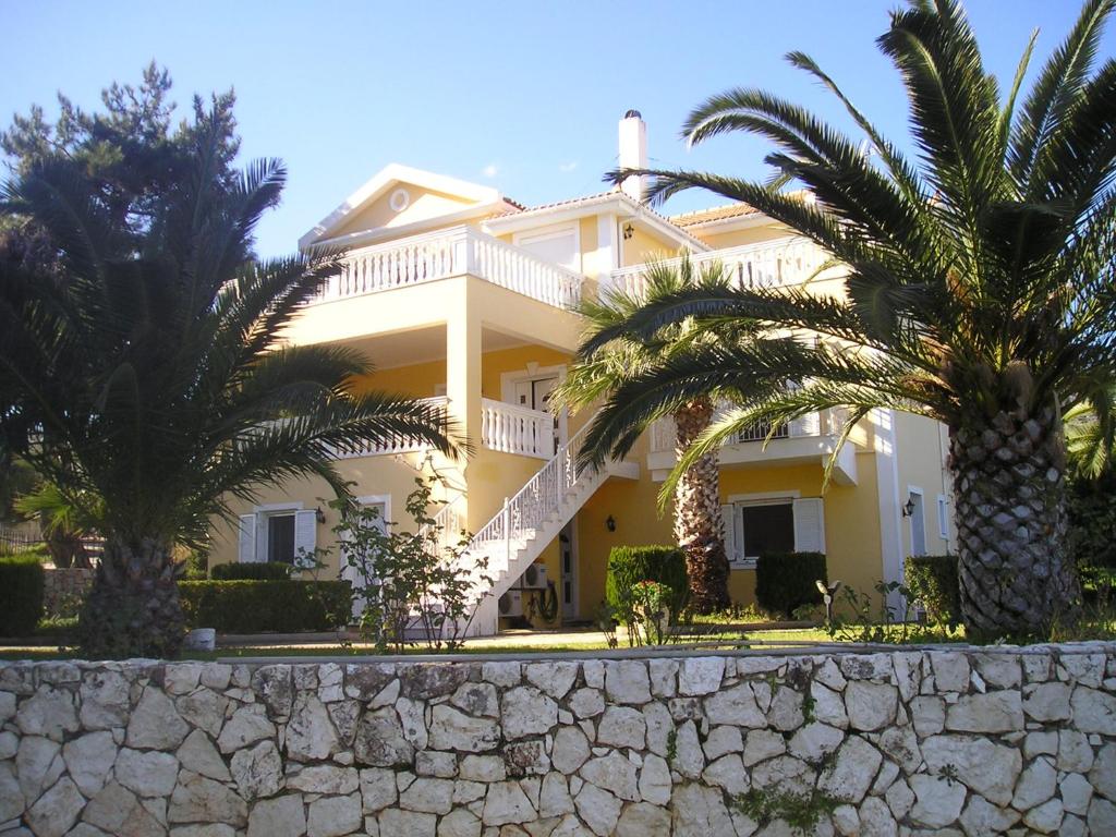 斯卡拉Nikolaos Studios Skala的一座大型白色房子,前面有棕榈树