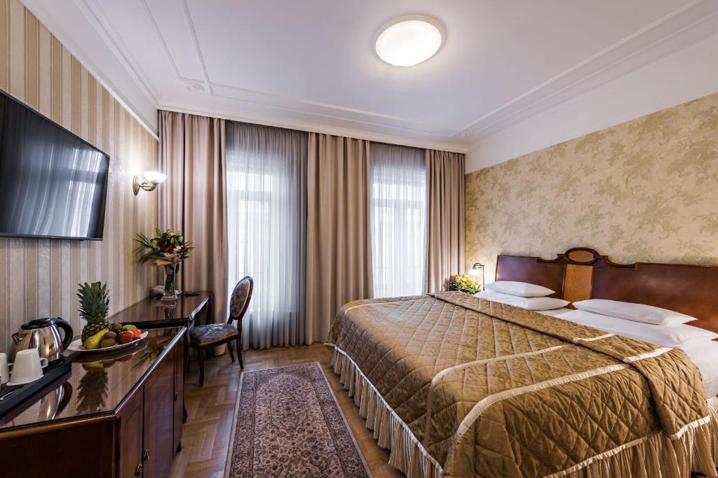 贝尔格莱德莫斯科酒店的酒店客房设有一张大床和一张书桌。