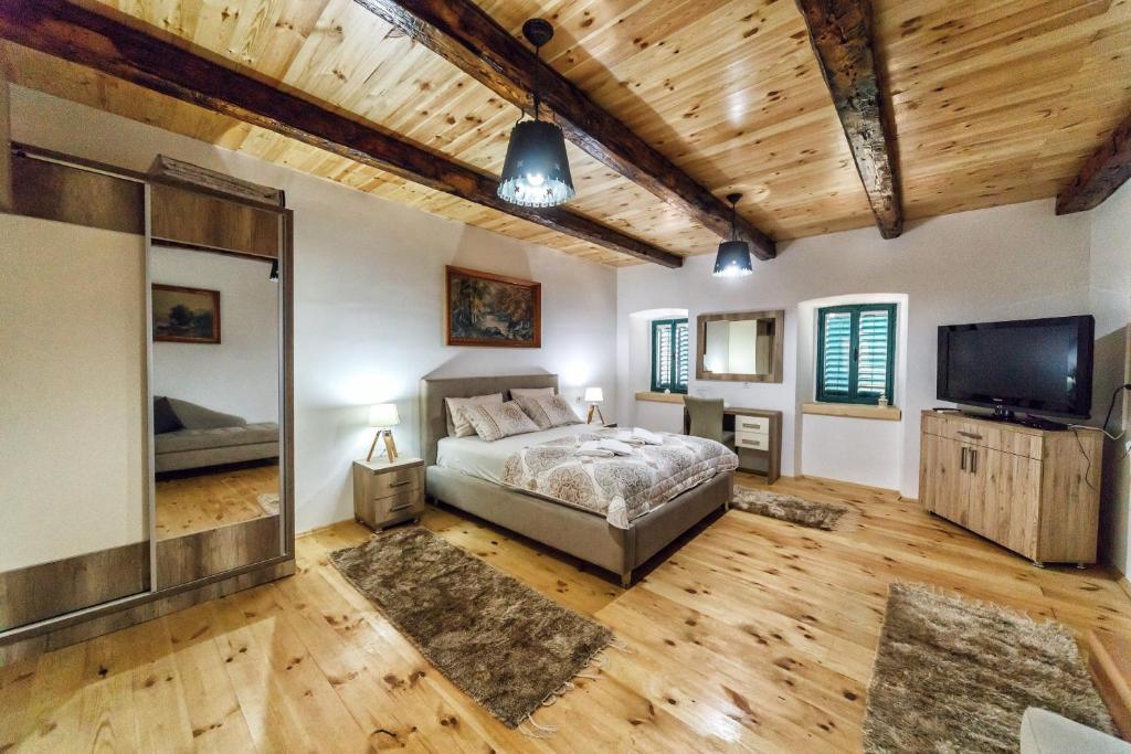 威尔帕扎Apartments "Old house Pajovic"的一间卧室配有一张床和一台平面电视