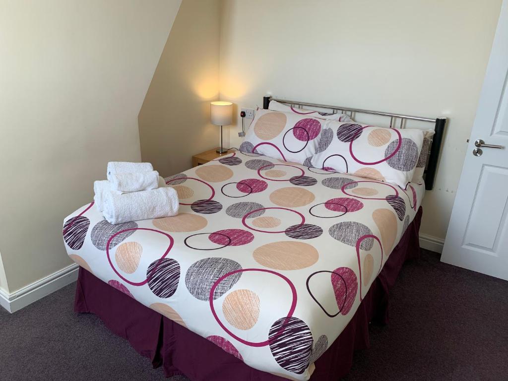 卡迪夫Austins Guest House的一间卧室配有一张带花卉床罩的床