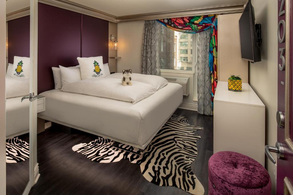 纽约Staypineapple, An Artful Hotel, Midtown New York的卧室配有白色的床和斑马地毯。
