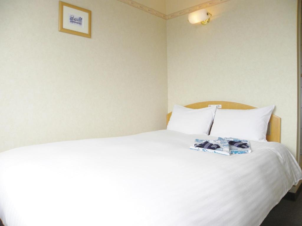 米泽市Yonezawa - Hotel / Vacation STAY 16072的卧室配有一张白色的床,上面有书
