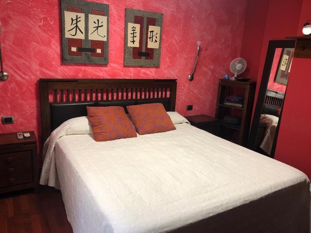 坎德拉里亚Casa M.的红色卧室配有带2个橙色枕头的床