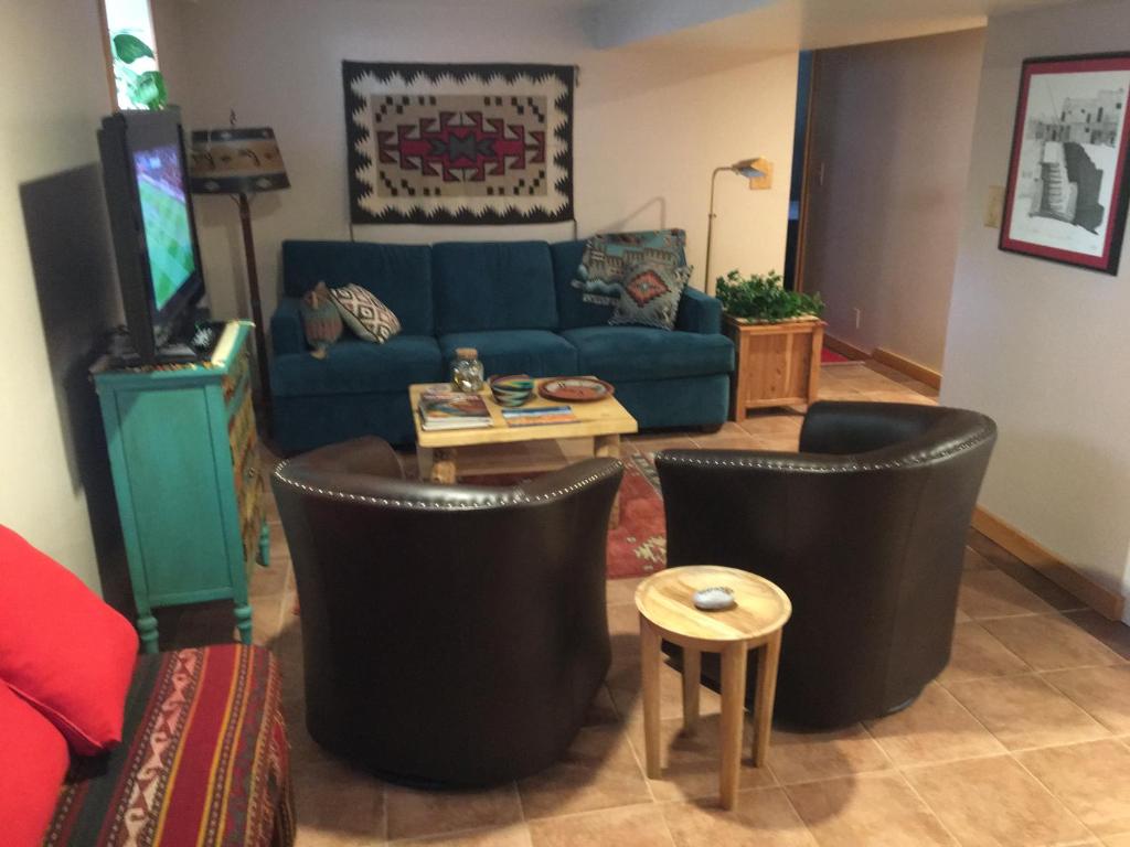 丹佛4047 Wyandot Street的客厅配有蓝色的沙发和黑色椅子