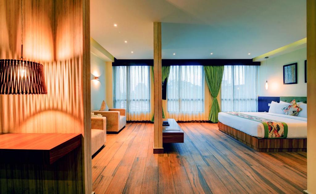 西里古里Udaan Clover Hotel Banquet & Spa的酒店客房,配有床和沙发