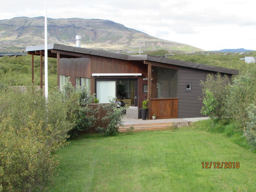 ÚlfljótsvatnLuxury Vacation House for Summer and Winter的山丘上以山为背景的房子