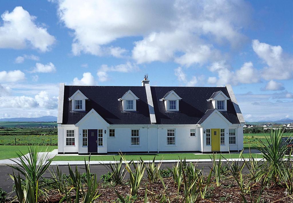 巴利巴宁Ballybunion Holiday Homes No 27的黑色屋顶的大型白色房屋