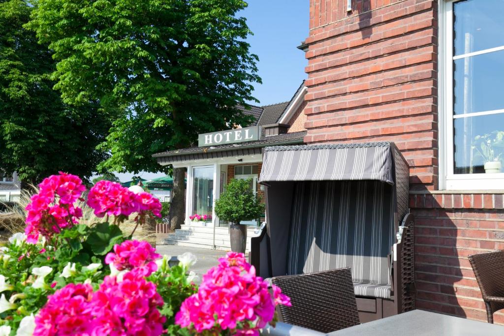 吕丁豪森Landgasthof-Hotel Zum Steverstrand的一座建筑前有粉红色花卉的酒店