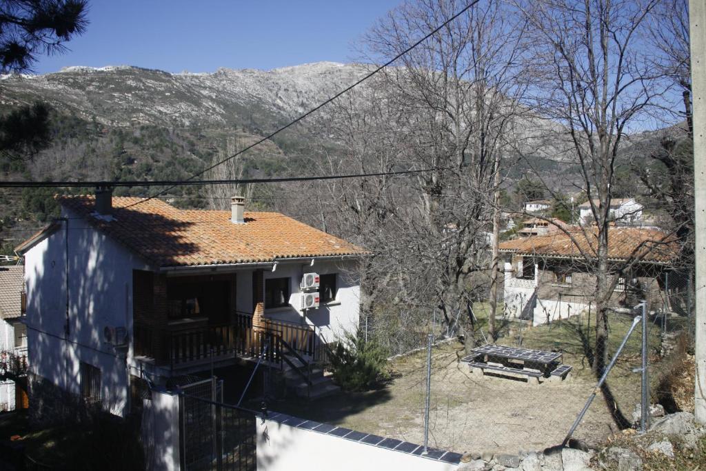 阿维拉Casa Rural Las Pegueras的一座带蓝色屋顶的山房
