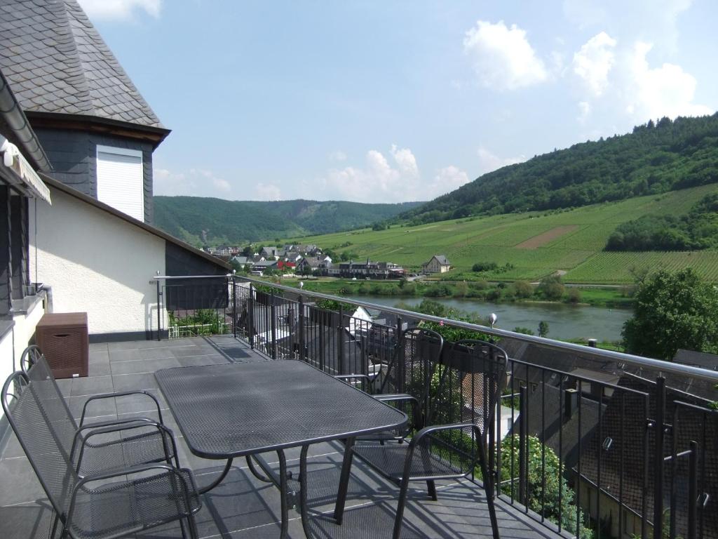 法尔维希Ferienwohnung Morgen的阳台配有桌椅,享有河流美景。