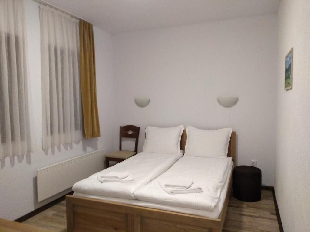 梅尔尼克Guesthouse White Margarit的一间卧室配有一张带白色床单的床和一扇窗户。
