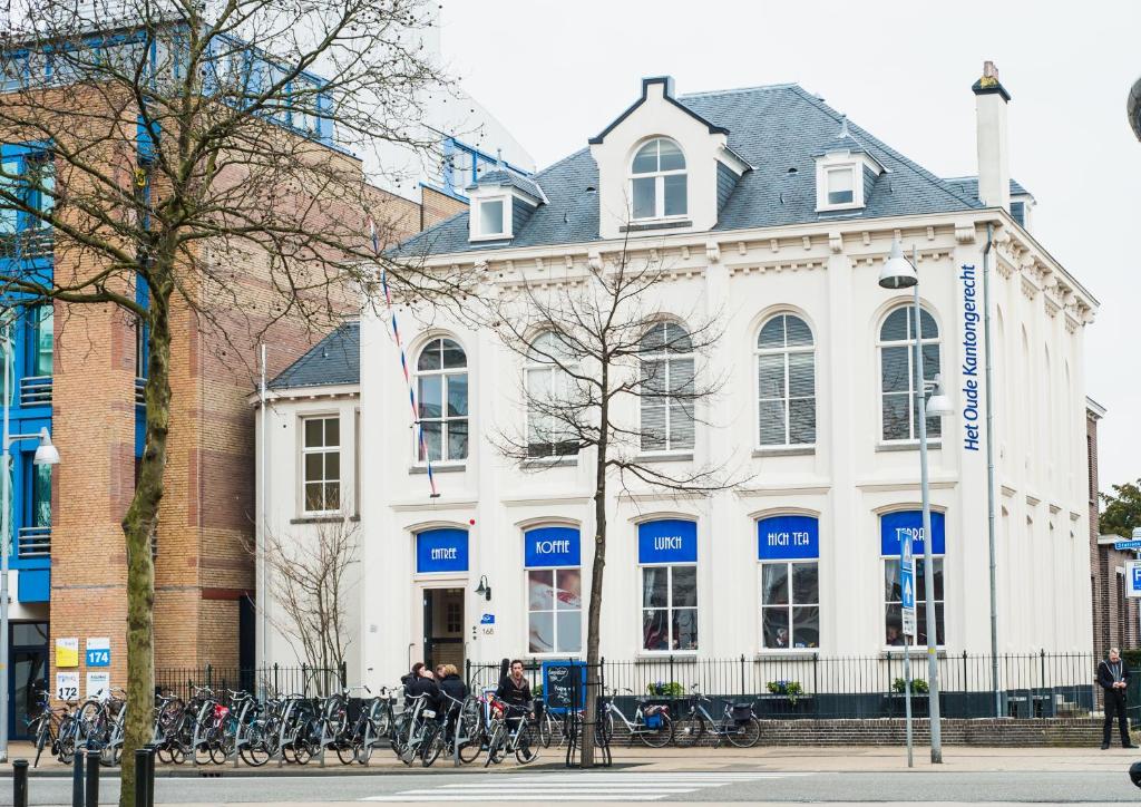 阿珀尔多伦Het Oude Kantongerecht的一座白色的建筑,前面有自行车停放