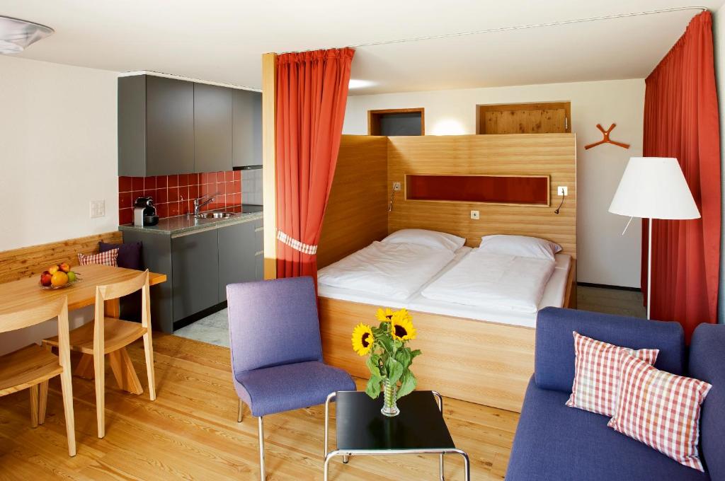 CluginHapimag Ferienwohnungen Andeer的小型公寓 - 带一张床和一张桌子及椅子