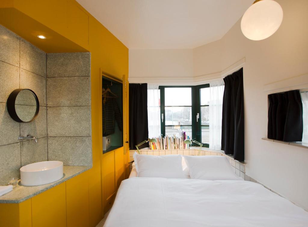 阿姆斯特丹SWEETS - Kattenslootbrug的一间卧室设有两张床、一个水槽和镜子