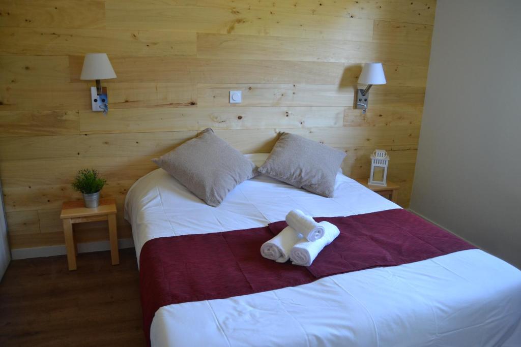 瑟鲁堡Village de vacances Les Lambrilles的一间卧室配有一张床,上面有两条毛巾