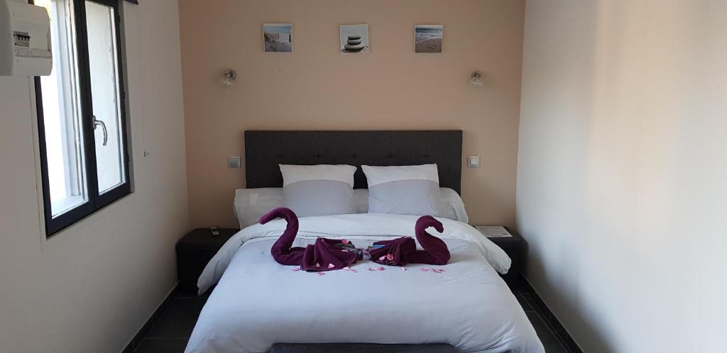 勒克罗图瓦BAIE DE SOMME - Le pourquoi pas的卧室内床边的两只粉红色天鹅