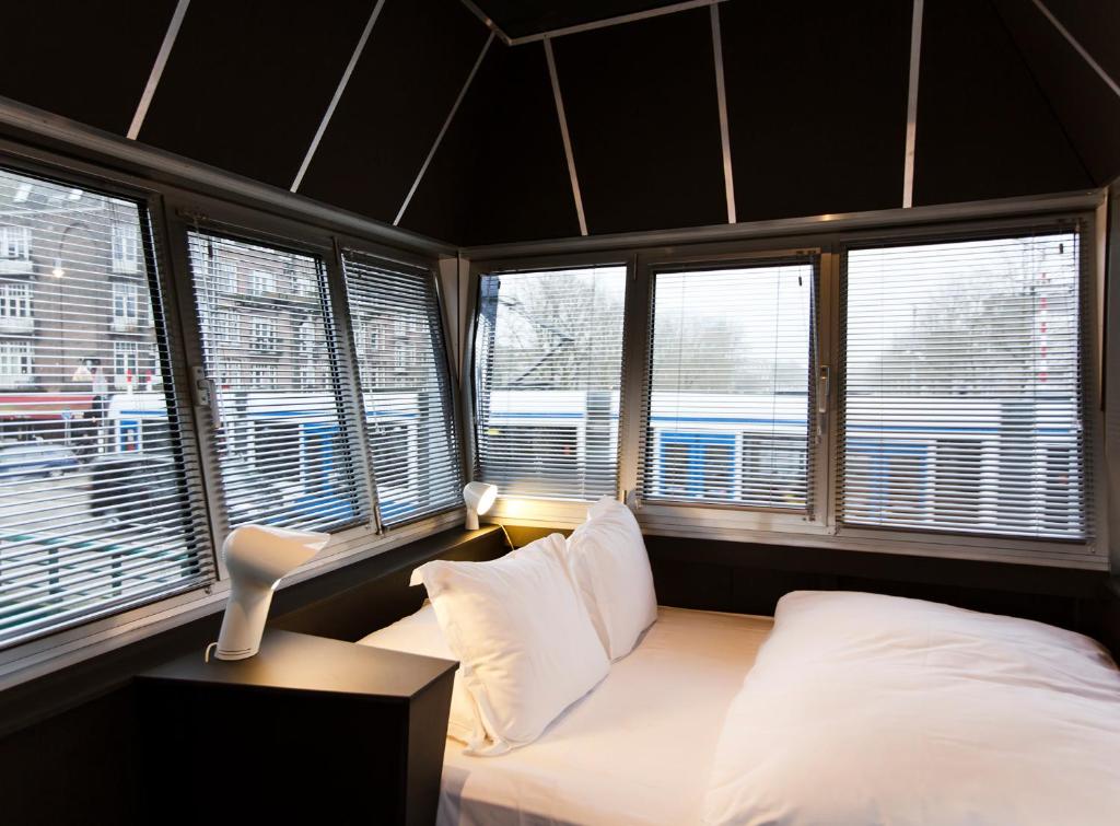 阿姆斯特丹SWEETS - Wiegbrug的卧室配有白色枕头和窗户。