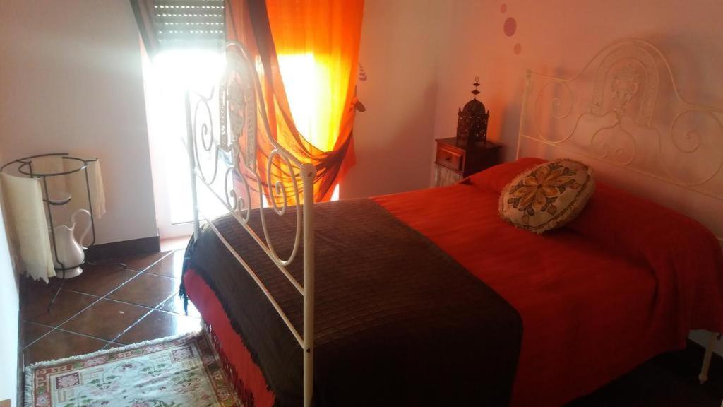 埃武拉Évora Romana Alojamentos T3 Cartuxa的一间卧室配有一张红色棉被的床