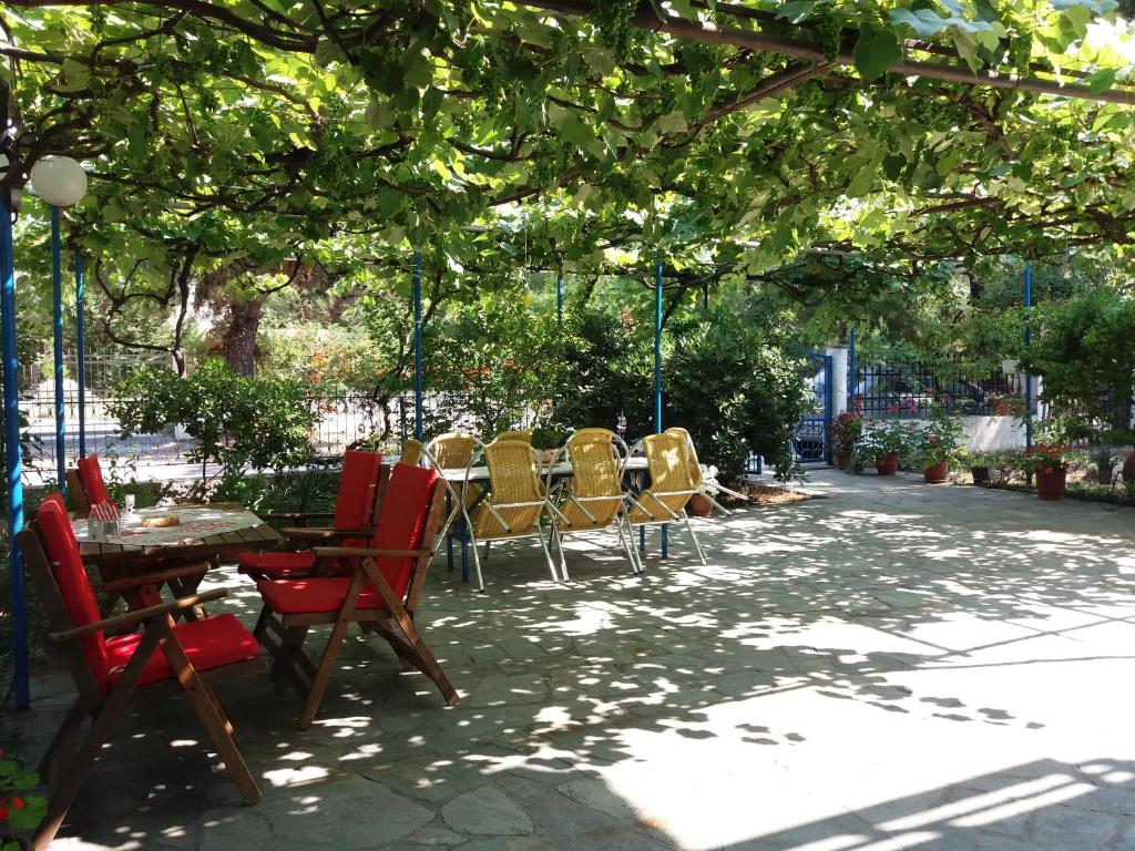 普里诺斯Tasos Rooms的树下带桌椅的庭院