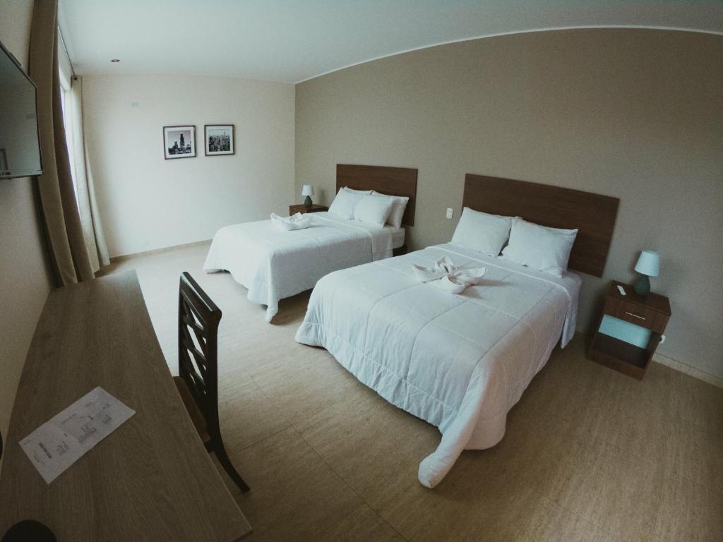 伊察Villa Oasis的酒店客房,配有两张带白色床单的床