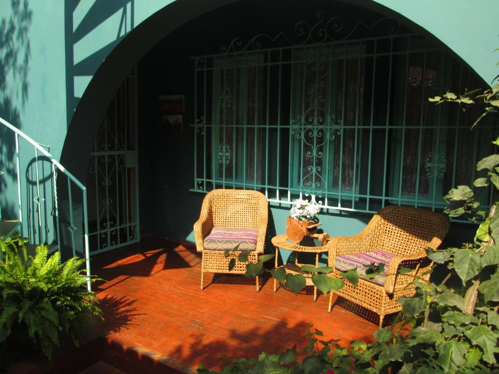 利马La Casona Azul的天井上配有2把藤椅和1张桌子